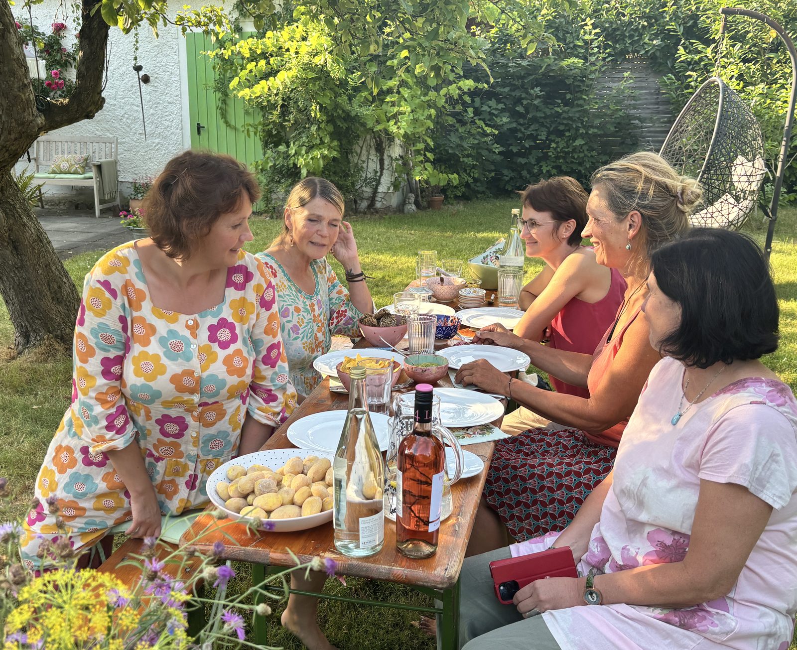 Teilnehmerinnen am gedeckten Tisch im Garten
